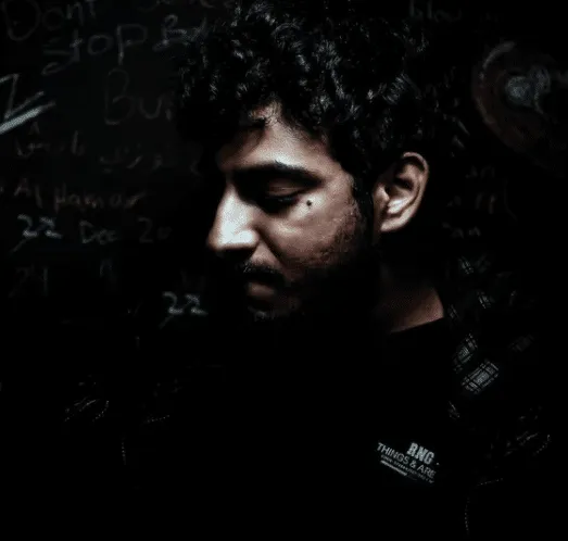 M.G. Darwish in front of a wall of chalk notes