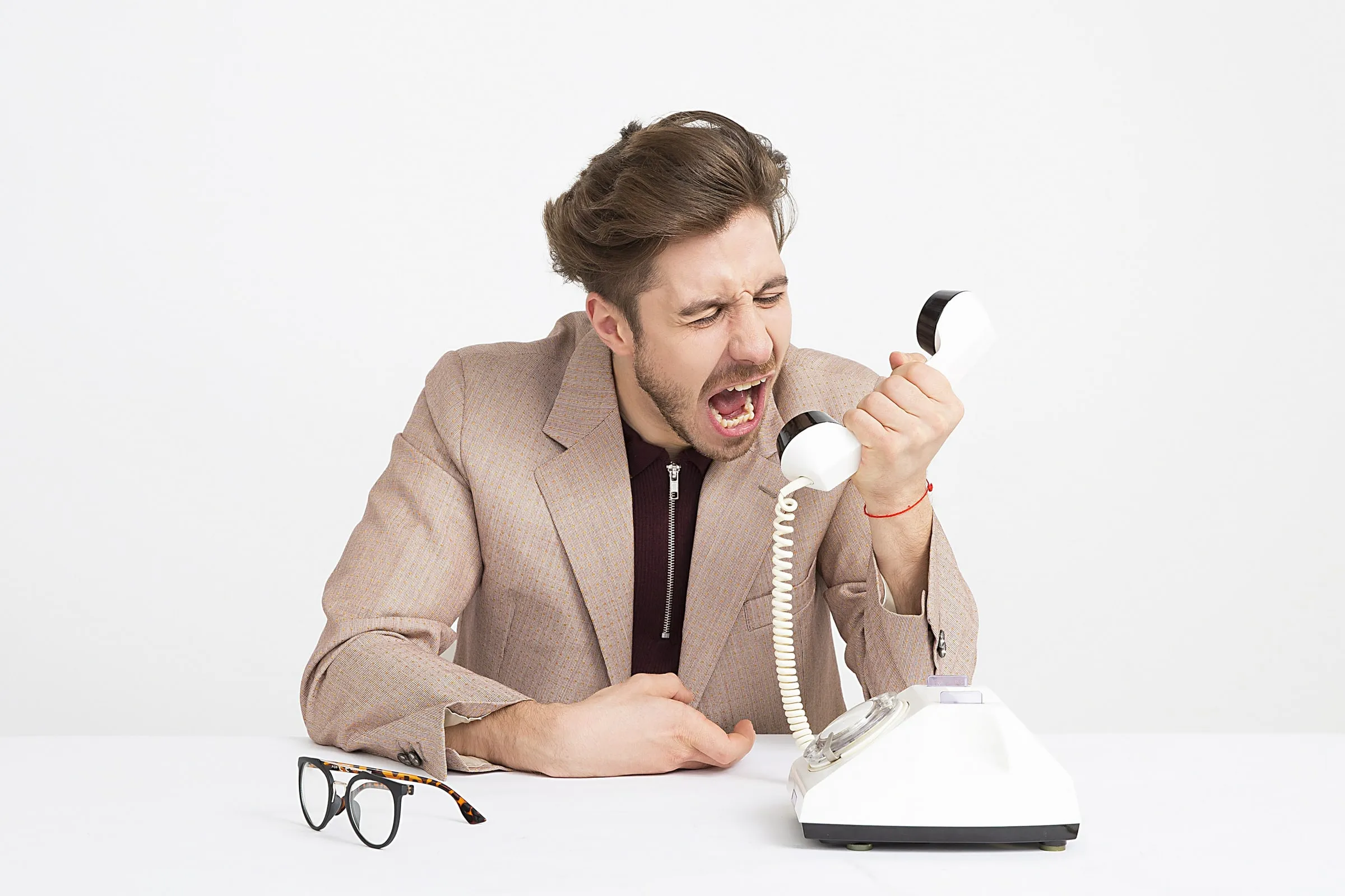 Man yelling into a phone during a frustrating conversation